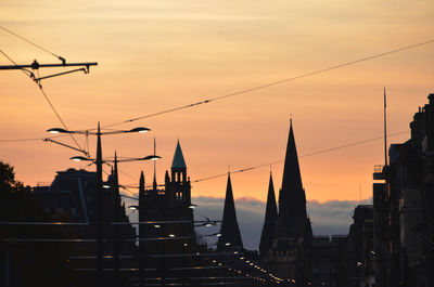 Historic church and street lights against sky during sunset in city