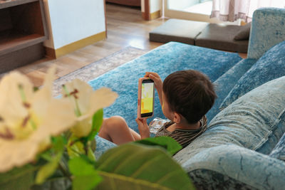 Low section of woman sitting on bed at home