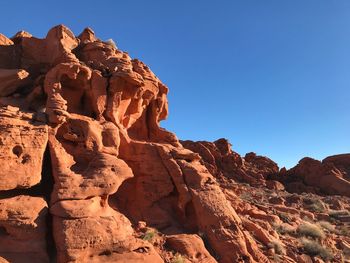 Low angle view of rock formation against clear blue sky