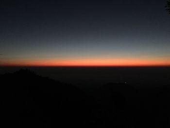 Silhouette landscape against sky at sunset