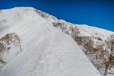 Scenic view of snowcapped mountains against clear blue sky