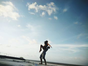 Full length of man running on beach against sky