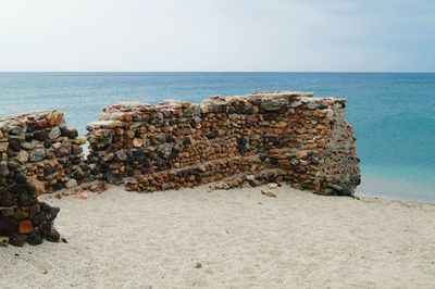 Rocks on beach against sky