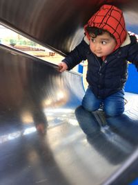 Cute boy kneeling in slide tunnel