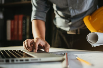 Midsection of man using laptop on table