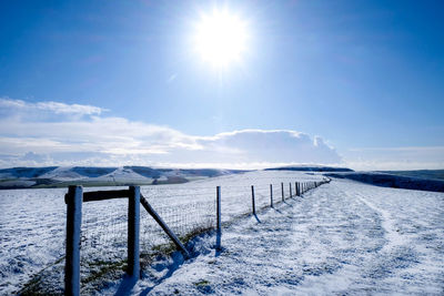 Scenic view of snow covered mountains against blue sky