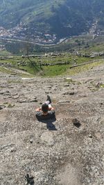 High angle view of man sitting on rock