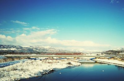 Scenic view of frozen lake against blue sky