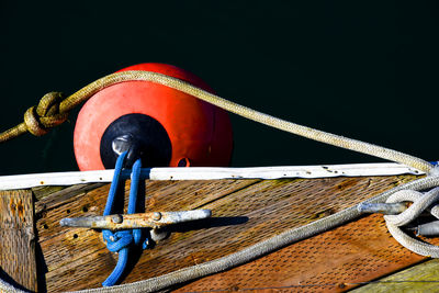 Close-up of rope tied on boat dock against dark water 