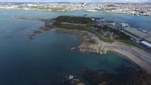 High angle view of sea by city against sky