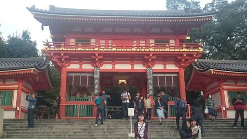 People in traditional temple against sky