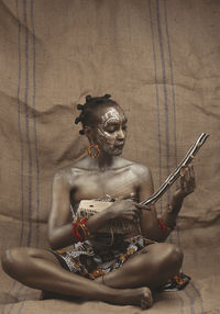 High angle view of eastafrican woman sitting on the floor with music instrument 