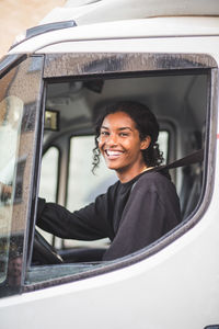 Portrait of smiling female mover driving truck