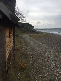 View of calm beach against cloudy sky