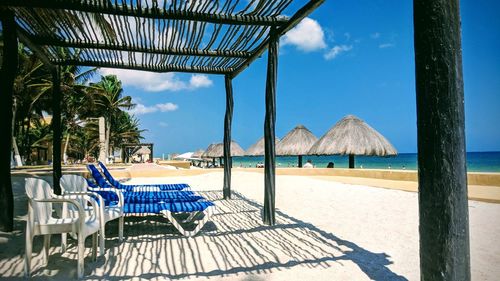 Chairs on beach against sky