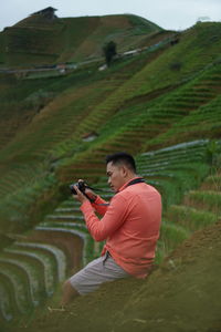 Low angle view of man sitting against sky