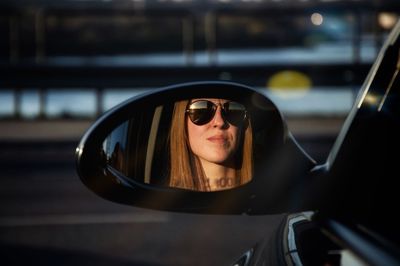 Woman wearing sunglasses while looking out of car window