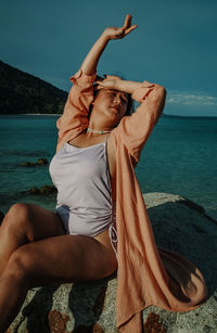 Rear view of woman standing at beach