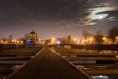 Illuminated bridge over river in city at night