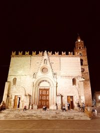 Group of people in front of historic building at night