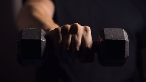 Close-up of hand holding black background