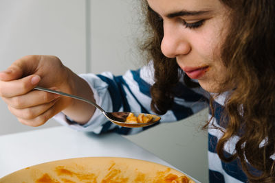Close-up of girl eating pasta on table