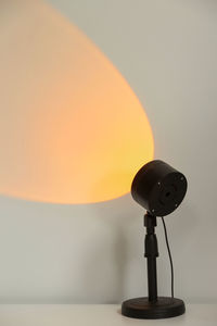 Close-up of electric lamp against orange sky