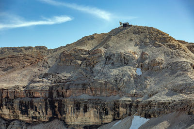 Low angle view of rocks on mountain against sky