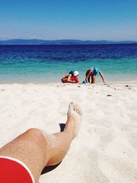 People at beach against blue sky