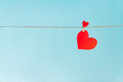 Close-up of red heart shape against blue wall