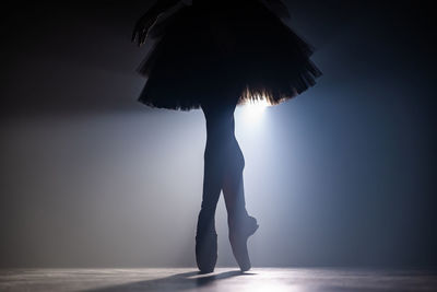 Low section silhouette ballet dancer dancing on stage