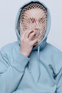 Man wearing mesh bag against white background