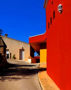 Alley amidst buildings against clear sky