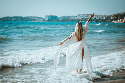 Woman wearing shirt while wading in sea