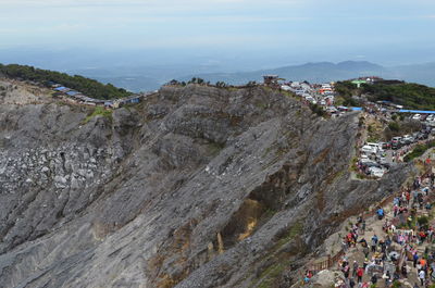 High angle view of crowd on rock against sky