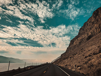 Road by mountain against sky