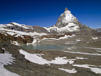 Scenic view of snowcapped mountains against clear blue sky