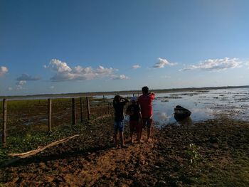 People standing on beach against sky