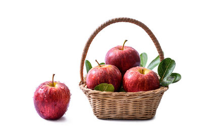 Close-up of apples in basket against white background