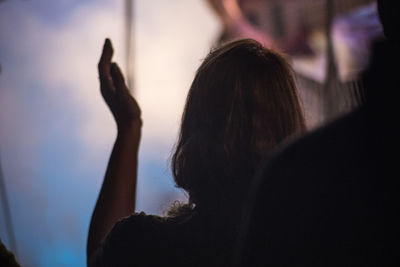 Rear view of woman with arms raised