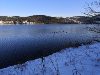 Scenic view of lake against sky during winter