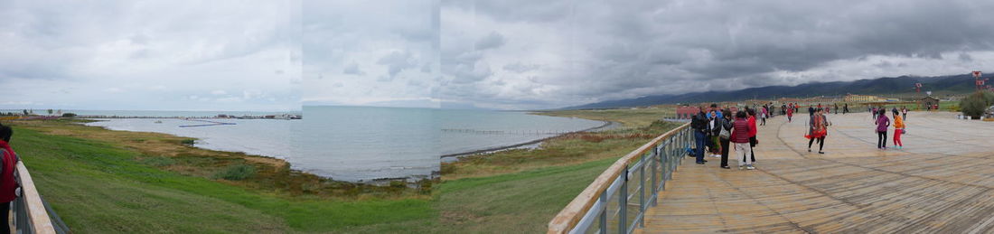 Panoramic view of people on beach against sky