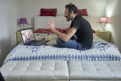 Man sitting on bed at home