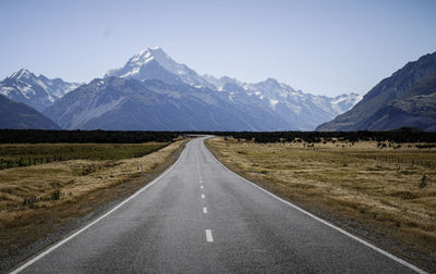 Road amidst mountains against clear sky