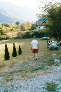 Rear view of woman walking on field