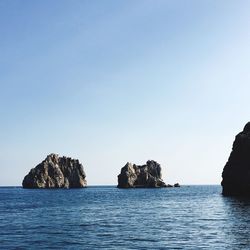 View of island in sea against clear sky