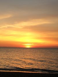 Scenic view of sea against dramatic sky during sunset