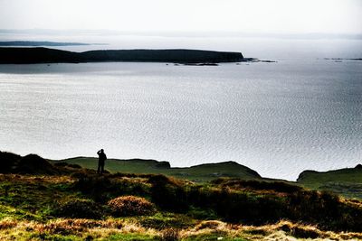 Distant view of man standing on cliff