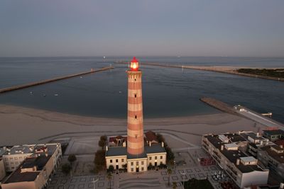 Aerial view of sea and cityscape against sky