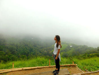 Full length of woman standing on land against sky